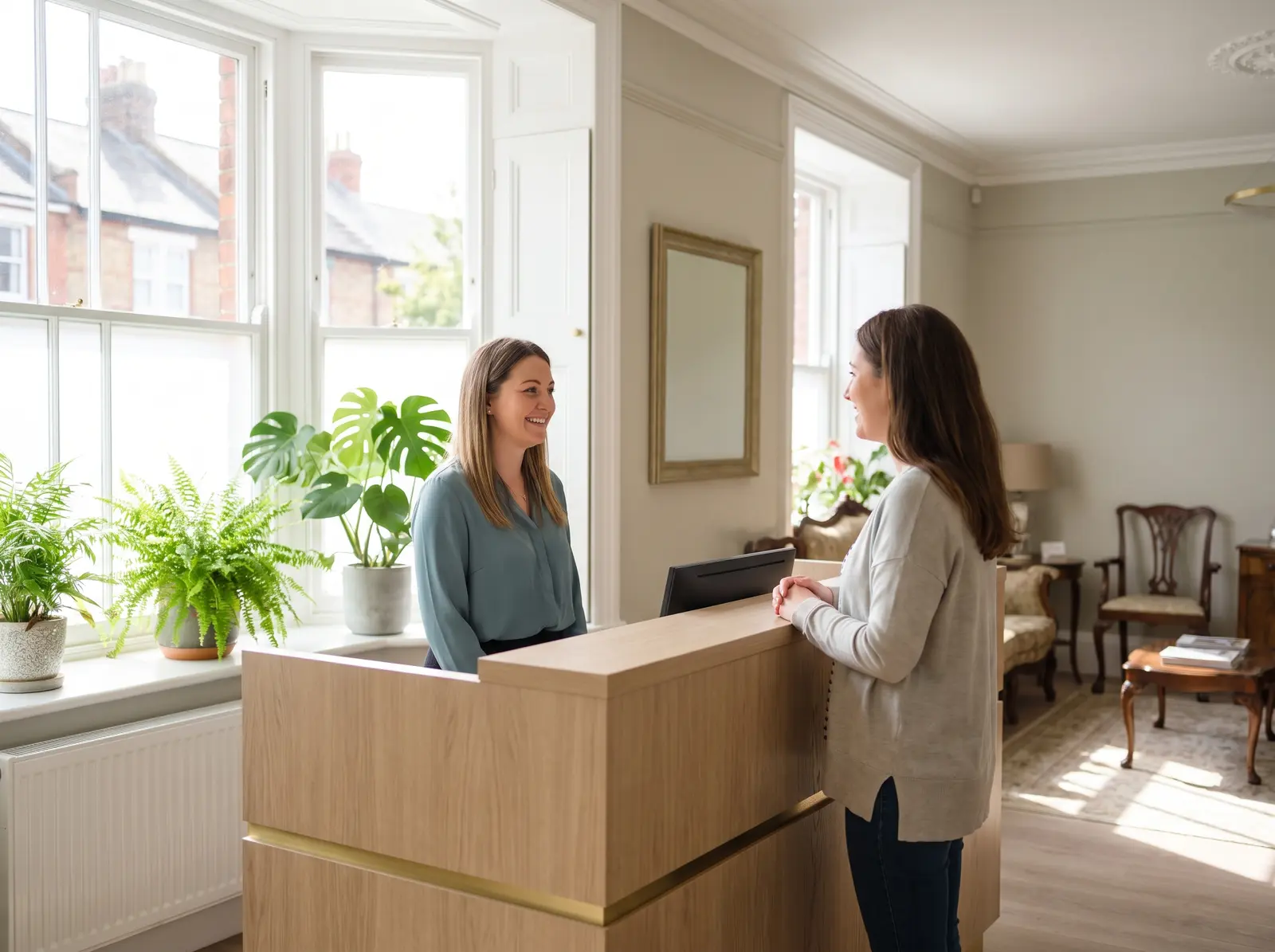 Illustrative scene of a receptionist welcoming a visitor at a practice reception desk